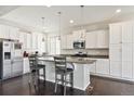 Bright kitchen with white cabinets, stainless steel appliances, granite countertops, and an island with bar seating at 19802 E 54Th Ave, Denver, CO 80249