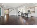 Open-concept living area featuring hardwood floors, modern lighting, and seamless transition to the adjacent kitchen at 19802 E 54Th Ave, Denver, CO 80249