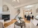 Inviting living room with a cozy fireplace, staircase, wood floors, and an open dining area at 5467 Zephyr Ct # 5467, Arvada, CO 80002
