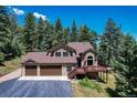 Charming two-story home featuring a three-car garage, stone accents and a welcoming porch at 8171 S Homesteader Dr, Morrison, CO 80465