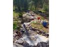 Outdoor rock water feature with a small waterfall running through boulders at 8171 S Homesteader Dr, Morrison, CO 80465