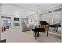 Spacious living room with a cozy fireplace, plush carpeting, and a grand piano reflecting luxury at 7201 E Quincy Ave # 102, Denver, CO 80237