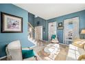 Bright living room featuring large windows, blue walls and tile floors at 5224 Snow Goose St, Brighton, CO 80601