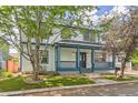 Two-story home with a inviting covered front porch, manicured lawn, and mature shade trees at 511 Noel Ave, Longmont, CO 80501