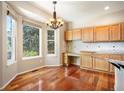 Kitchen dining nook with lots of windows for natural light, wooden floors, and chandelier at 15577 Greenstone Cir, Parker, CO 80134