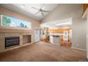 Open-concept living room with fireplace, hardwood floors and a large window with natural light at 15577 Greenstone Cir, Parker, CO 80134