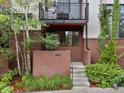 Inviting townhouse entrance featuring a small balcony, lush landscaping, and a well-maintained exterior at 1880 W 32Nd Ave, Denver, CO 80211