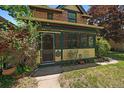 Close up shot of an inviting sunroom featuring yellow and green paint with an exterior door at 3764 Newton St, Denver, CO 80211