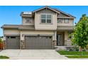 Two-story home showcasing a three-car garage, manicured lawn, and inviting curb appeal at 5779 Piney River Pl, Brighton, CO 80601