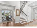 Bright entryway featuring a staircase with black railings, hardwood floors, and an adjacent dining room at 5984 S Paris Pl, Greenwood Village, CO 80111