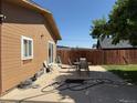 Backyard features a small patio area, wooden privacy fence, and ample yard space at 1000 Denver Ave, Fort Lupton, CO 80621