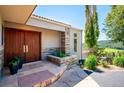 Inviting front entrance featuring a stone planter, flagstone path, and double wood doors at 33448 Alta Vista Dr, Evergreen, CO 80439