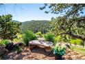 Gorgeous mountain view from a stone bench overlooking lush trees and foliage at 33448 Alta Vista Dr, Evergreen, CO 80439