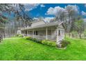 Well manicured lawn surrounds the home, enhanced by mature trees and a cozy porch at 18470 Canterbury Dr, Monument, CO 80132