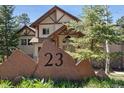 View of the front of a two-story home from behind a decorative stone displaying the home's address number at 23 Hess Ave, Golden, CO 80401
