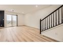 Open-concept living room with sleek floors, stairs and access to outdoor balcony at 3200 S Federal Blvd # 5, Denver, CO 80236
