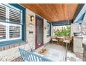 Inviting front porch with wooden swing, chairs, and a small table at 525 N Pearl St, Denver, CO 80203