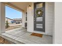 Close-up view of a welcoming front door with a wreath on a covered front porch at 2653 W 69Th Dr, Denver, CO 80221