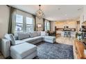 Bright, open living room featuring a comfortable sectional sofa and a view into the kitchen at 2653 W 69Th Dr, Denver, CO 80221