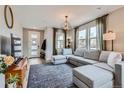 Cozy living room with a comfortable gray sectional sofa, stylish lighting, and natural light at 2653 W 69Th Dr, Denver, CO 80221