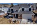 An elevated view of a two-story house with a brick and white exterior and a gray roof at 69 Dawn Heath Cir, Littleton, CO 80127