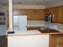 Functional kitchen featuring wood cabinets, white appliances, and a breakfast bar at 19692 E Mann Creek Dr # D, Parker, CO 80134