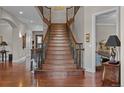 Grand staircase with ornate iron railings and hardwood steps leading to the upper level of the home at 1160 Monaco Pkwy, Denver, CO 80220