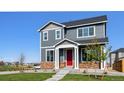 Charming two-story home with a red front door and well-manicured lawn at 28610 E 8Th Pl, Watkins, CO 80137