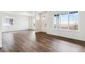 Bright living room featuring wood floors, white walls and large windows at 28610 E 8Th Pl, Watkins, CO 80137