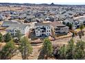 Expansive aerial view of the neighborhood and this home's backyard, with surrounding homes and distant views at 3131 Keepsake Way, Castle Rock, CO 80109