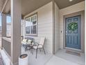 Inviting covered front porch featuring comfortable seating and a stylish entrance door at 152 Western Sky Cir, Longmont, CO 80501