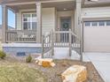 Cozy front porch with seating area, decorative wreath on front door, and manicured landscaping at 152 Western Sky Cir, Longmont, CO 80501