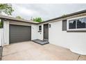 A well-lit doorway and garage entrance with a neat painted exterior, complemented by dark shutters and matching trim at 320 S Jersey St, Denver, CO 80224