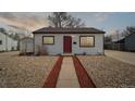 Inviting home with a red door, rock landscaping, and a concrete pathway at 766 Fulton Ave, Brighton, CO 80601
