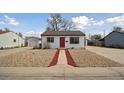 Charming single-story home with a bright red door and low maintenance rock landscaping at 766 Fulton Ave, Brighton, CO 80601