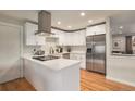 Bright kitchen with white cabinetry, stainless steel appliances, and hardwood floors, offering a clean and modern aesthetic at 12292 W 65Th Ave, Arvada, CO 80004