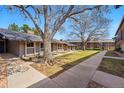 Exterior view of condos surrounded by mature trees and a green lawn at 6495 E Happy Canyon Rd # 62, Denver, CO 80237