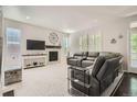 Cozy living room featuring plush seating, a fireplace with stone surround, and plantation shutters at 9523 Gray Ct, Westminster, CO 80031