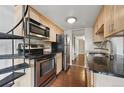 This kitchen features stainless steel appliances, granite countertops, and maple cabinetry at 9797 E Peakview Ave # C10, Englewood, CO 80111