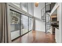 Bright living room with wood floors, balcony, and a unique spiral staircase at 9797 E Peakview Ave # C10, Englewood, CO 80111