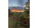 Gorgeous backyard with green space, trees, and mountain views during a colorful sunset at 12693 W 82Nd Ln, Arvada, CO 80005