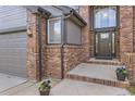 Welcoming front entrance with beautiful brick accents and a three-car garage at 12693 W 82Nd Ln, Arvada, CO 80005
