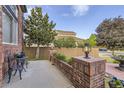 Charming outdoor space with mature trees, a stone wall, and a bistro table at 12693 W 82Nd Ln, Arvada, CO 80005