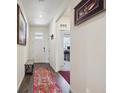 Bright entryway hallway featuring hardwood floors, white walls, and tastefully displayed artwork for a welcoming ambiance at 14670 Guernsey Dr, Mead, CO 80542