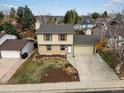 Two-story house with two-car garage, brick facade and tan siding, with a rock and landscaped front yard at 18093 E Milan Pl, Aurora, CO 80013