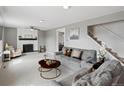 Bright living room featuring a white brick fireplace, ceiling fan, and gray couches on neutral carpet at 18093 E Milan Pl, Aurora, CO 80013