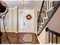 Elegant entryway with hardwood floors, a decorative wreath and staircase at 10697 W Roxbury Ave, Littleton, CO 80127