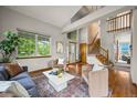Inviting living room with hardwood floors, a staircase, and large windows at 1190 W 11Th Ct, Broomfield, CO 80020