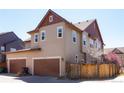 Exterior view showcasing attached two-car garage and fenced yard at 8951 E 59Th Pl, Denver, CO 80238