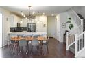 Open-concept kitchen and dining area with modern lighting, white cabinetry, and stainless steel appliances at 8951 E 59Th Pl, Denver, CO 80238